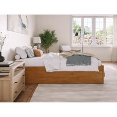 a bed room with a neatly made bed next to a dresser and a window in it