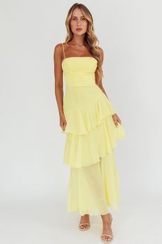 Back in stock! Our Parisian Summer Yellow Tiered Maxi Dress is the perfect wedding guest dress or sorority formal dress! Featuring a ruched bodice, spaghetti straps and a playful asymmetrical tiered skirt. Zipper back.