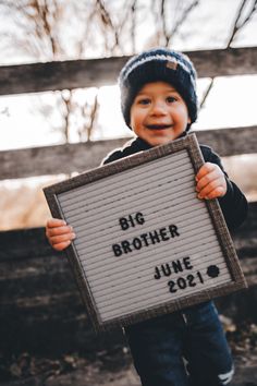 a young boy holding up a sign that says, big brother june 20 - 21