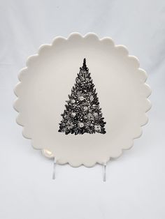 a white plate with a black christmas tree on it