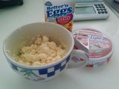 a bowl of cereal and yogurt next to a calculator on a counter