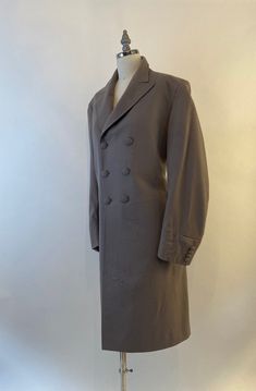 "Well tailored double breasted wool coat by Morty Sills has covered buttons in the front, on the cuffs and in the back. Coat is lined in a taupe satin and has two inside pockets, slight shoulder pads and a back kickpleat. In excellent vintage condition The Morty Sills brand has been referred to as \"the tailor to the CEO\". Morty Sills specialized in high-end formal/semi-formal wear for men and women. Handcrafted in the USA. Shoulders 17\" Chest 40\" Waist 36\" Hips 42\" Length from back of neck Fitted Beige Double-breasted Pea Coat, Fitted Double-breasted Pea Coat With Button Cuffs, Fitted Gabardine Pea Coat With Long Sleeves, Fitted Gabardine Pea Coat, Fitted Long Sleeve Gabardine Pea Coat, Formal Double-breasted Pea Coat With Button Cuffs, Fitted Pea Coat With Button Cuffs And Lapel Collar, Elegant Double-breasted Pea Coat With Button Cuffs, Formal Fitted Pea Coat With Button Cuffs