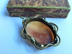 a piece of jewelry sitting on top of a white table next to a wooden box