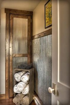 a bunch of towels are stacked up in a storage area next to a door and window