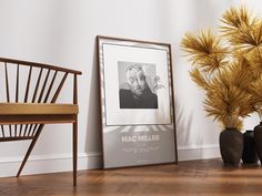 there is a framed photo next to two vases and a chair on the floor