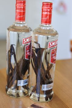 two bottles of smir vodka sitting on top of a wooden table