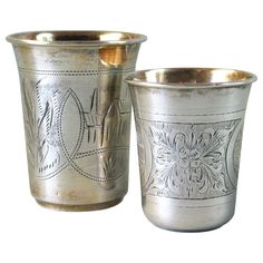 two silver cups sitting next to each other