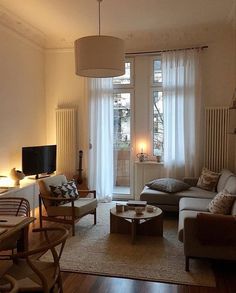 a living room filled with furniture and a flat screen tv on top of a wooden table