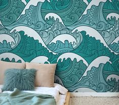 a bed sitting next to a wall covered in green and white wave design murals on it's walls