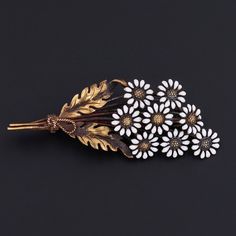 Daisies are historically a symbol of purity, innocence, and loyal love and commonly carried by brides on their wedding day. This antique brooch (circa 1910-1920) features a bouquet of 14k gold and white enamel daisies. The pin bears the makers mark for Carter Gough. The piece measures 0.7 inches by 1.75 inches wide and is in very good condition. We have many other fantastic offerings of period fine jewelry posted on our Etsy store, so please consider browsing our other items. We send all items i White Vintage Brooch Lapel Pin, Vintage White Flower Pins, Vintage White Flower Enamel Pin, Yellow Gold Flower Brooch, Gold Flower-shaped Brooches For Gifts, Antique Gold Flower Brooch, Victorian Gold Flower Brooch, Vintage Gold Flower Shaped Brooch, Jewelry Post