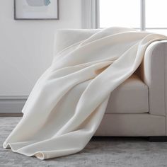 a white couch with a blanket on top of it