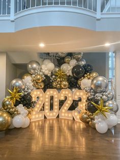 a large balloon arch with the number 20 on it and balloons in the shape of letters