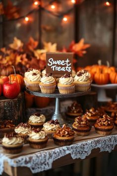 a table topped with lots of cupcakes covered in frosting and toppings