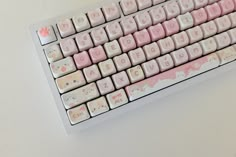 a pink and white keyboard with hello kitty keys