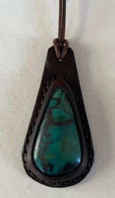 "Leather Necklace with Semi Precious Chrysocolla Cabochon. The leather is cut and wet molded over the cabochon. The two layers of leather are handstitched together and the edges are dyed and waxed.  The rolled leather cord is 20\" long with a stainless steel clasp.  This pendant measures 2 7/8\" tall and 1 1/2\" wide. Handmade in California" Artisan Leather Necklace For Everyday, Brown Leather Teardrop Jewelry, Brown Leather Jewelry With Patina, Green Leather Jewelry Gift, Green Leather Jewelry For Gifts, Green Leather Jewelry As A Gift, Green Leather Artisan Jewelry, Artisan Brown Leather Necklace, Southwestern Turquoise Leather Jewelry