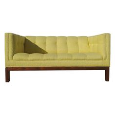 a yellow couch sitting on top of a wooden frame