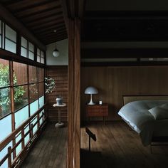 a bedroom with wooden walls and flooring next to a window