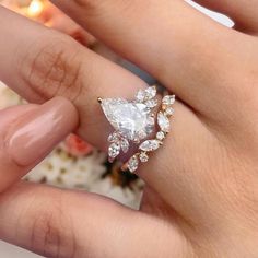 a woman's hand holding an engagement ring in her left hand, with diamonds on it