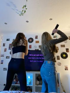 two women standing in front of a flat screen tv