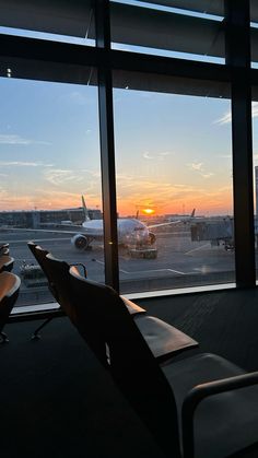 the sun is setting at an airport terminal