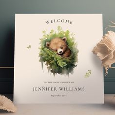 a welcome card with an image of a bear peeking out from the leaves and flowers