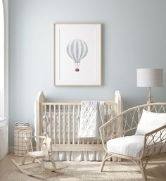 a baby's room with a rocking chair, crib and framed hot air balloon