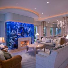 a living room filled with furniture and a large fish tank in the middle of it