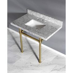 a bathroom sink with a marble top and gold legs on the floor in front of a gray wall