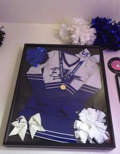 a display case with cheerleader's uniform and pom poms on it