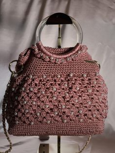 Pearl Pink Knitted Handbag with pink shoulder strap Introducing our exquisite Pearl Pink Knitted Handbag with pink shoulder strapp. This unique purse is a perfect blend of style and craftsmanship, meticulously crafted. The purse features a beautifully knitted design, adding a touch of elegance to any outfit. The intricate details highlight the skill and dedication put into creating this one-of-a-kind accessory. The silver shoulder strap adds a modern and chic element, allowing for easy and comfo Chic Pink Crochet Bag With Adjustable Strap, Pink Handheld Shoulder Bag With Braided Handles, Pink Crochet Satchel Bag With Adjustable Strap, Pink Satchel Crochet Bag With Adjustable Strap, Elegant Crochet Shoulder Bag With Adjustable Strap, Chic Pink Crochet Shoulder Bag, Pink Double Handle Crochet Bag, Pink Crochet Bag With Double Handles, Handmade Pink Crochet Shoulder Bag