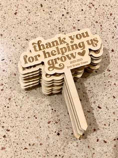 a wooden sign that says thank you for helping us grow