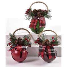 two christmas ornaments with pine cones and red balls on them, tied to twine