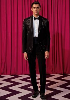 Step into elegance with our Black Textured Tuxedo Set. Crafted from luxurious textured suiting, this set features an elegant black blazer embellished with intricate linear embroidery. Paired with an embellished bowtie, sash, pintuck shirt, and pants, it's the ideal choice for cocktails or wedding receptions. Make a statement and exude sophistication in this stunning tuxedo set. Components : 5 (Blazer, Shirt, Bowtie, Sash and Pants) Composition : Textured Suiting Care: Dry Clean Only and Vacuum Storage This product can be customized for sleeves, length of blouse and neckline Delivery : 4-6 weeks as the product is hand crafted. Check Size Guide or choose MySize for free customisation (All Sizes above XL can be made at 15% additional cost) For more information and sizes please contact fabilic Linear Embroidery, Pintuck Shirt, Vacuum Storage, Indian Wedding Wear, Blazer Shirt, Wedding Receptions, Black Textures, Black Blazer, Shirt And Pants