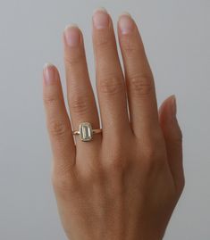 a woman's hand with a gold ring on it and a diamond in the middle