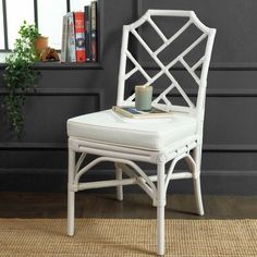 a white chair sitting on top of a rug next to a window