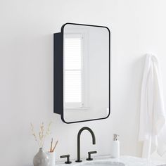 a bathroom sink with a mirror above it and a towel hanging on the wall next to it