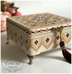 a decorative box with a tassel hanging from it's side on a table