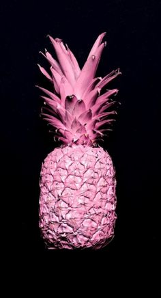 a pink pineapple sitting on top of a black table