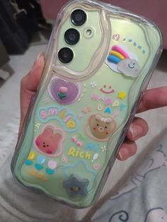 someone holding up a phone case with stickers on it