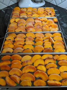 several trays filled with sliced peaches on top of a counter