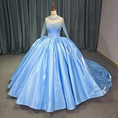 a blue ball gown on display in front of a curtain