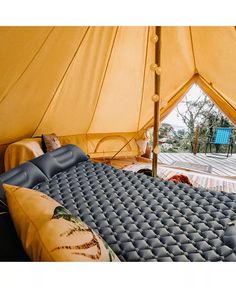 the inside of a tent with an air mattress and pillows on it's side