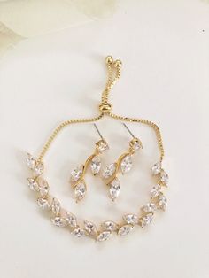 This stunning set will add the perfect touch of sparkle and elegance to your wedding or special event outfit! Made with high quality materials, these CZ pieces will be sure to impress in person and in photographs. ... i n f o  +  d e t a i l s ... Made of AAA quality Cubic Zirconia stones Available in Gold plated metal Approx 3.5cm long x 1.5cm wide drop earrings Adjustable bracelet to fit most *Due to hygienic reasons, no returns or exchanges permitted on hair accessories or earrings* .... p l Elegant Gold Bridal Accessories With Cubic Zirconia, Gold Cubic Zirconia Bridal Accessories For Gift, Gold Cubic Zirconia Bridal Accessories As Gift, Elegant Gold Hand Set Bridal Accessories, Elegant Hand Set Gold Bridal Accessories, Adjustable Gold Bridal Set For Formal Occasions, Elegant Adjustable Bridal Sets For Formal Occasions, Elegant Bracelets With Matching Earrings For Party, Gold Cubic Zirconia Bridal Earrings For Bridesmaids