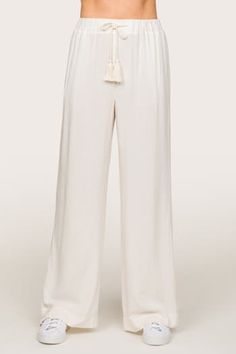 Crafted from a blend of linen and rayon, these breathable pants offer a luxurious drape and an incredibly soft hand feel. Designed for ultimate comfort, these high-rise pants feature an elastic waistband, a stationary tassel tie, and wide straight legs. With practical pockets and versatile styling options, they effortlessly transition from beach days to brunch outings, showcasing the epitome of laid-back elegance. Summer weight linen blend 29.75" inseam 14" high rise pant Straight, wide leg Full White Rayon Bottoms For Vacation, Chic Linen Bottoms With Elastic Waistband, Chic Harem Pants For Vacation, Elegant Viscose Wide Leg Pants For Summer, Chic Viscose Pants For Vacation, Solid Rayon Beach Bottoms, Chic Harem Pants With Elastic Waistband For Vacation, Elegant High-waisted Pants For Vacation, Elegant High-waisted Vacation Pants