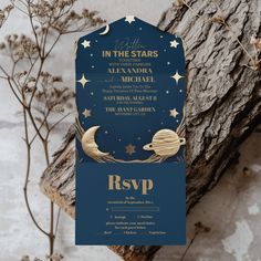 a blue and gold wedding card with stars in the sky, on top of a tree branch