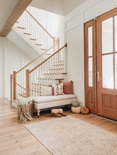 a white couch sitting under a stair case next to a wooden door