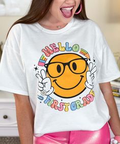 Introducing our "Hello Your Grade Smile Graphic Shirt," a cheerful and engaging addition to any teacher or student's wardrobe. Available in sizes YXS through 5XL, this shirt features a smiley face with the word "SMILE" above and "Your Grade" below, customizable from preschool to 5th grade, making it perfect for creating a positive and welcoming environment in the classroom.
Crafted from high-quality, soft materials, this shirt ensures all-day comfort, making it ideal for teachers greeting their new class or students starting a new school year. The "Hello Your Grade Smile Graphic Shirt" adds a fun and friendly touch to any outfit, encouraging smiles and positivity.
Celebrate the joy of learning and the start of a new school year with this versatile and comfortable graphic shirt. Whether you Playful White T-shirt With Smiley Face, Fun Slogan T-shirt For School, Fun Cotton T-shirt With Smiley Face, Casual Relaxed Fit T-shirt For Back To School, Fun Slogan Tops For School, Fun T-shirt With Funny Print For Back To School, Spring School T-shirt With Slogan, Spring Slogan T-shirt For School, Slogan T-shirt For School In Spring