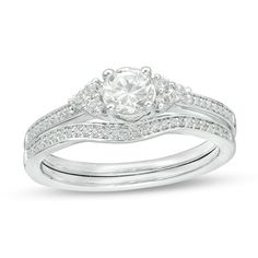 a diamond engagement ring set with two matching bands on the band, and a round cut diamond