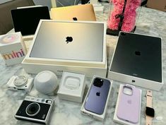 an assortment of apple products are displayed on a marble countertop in front of a pink teddy bear