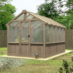 a small wooden greenhouse sitting on top of a grass covered field